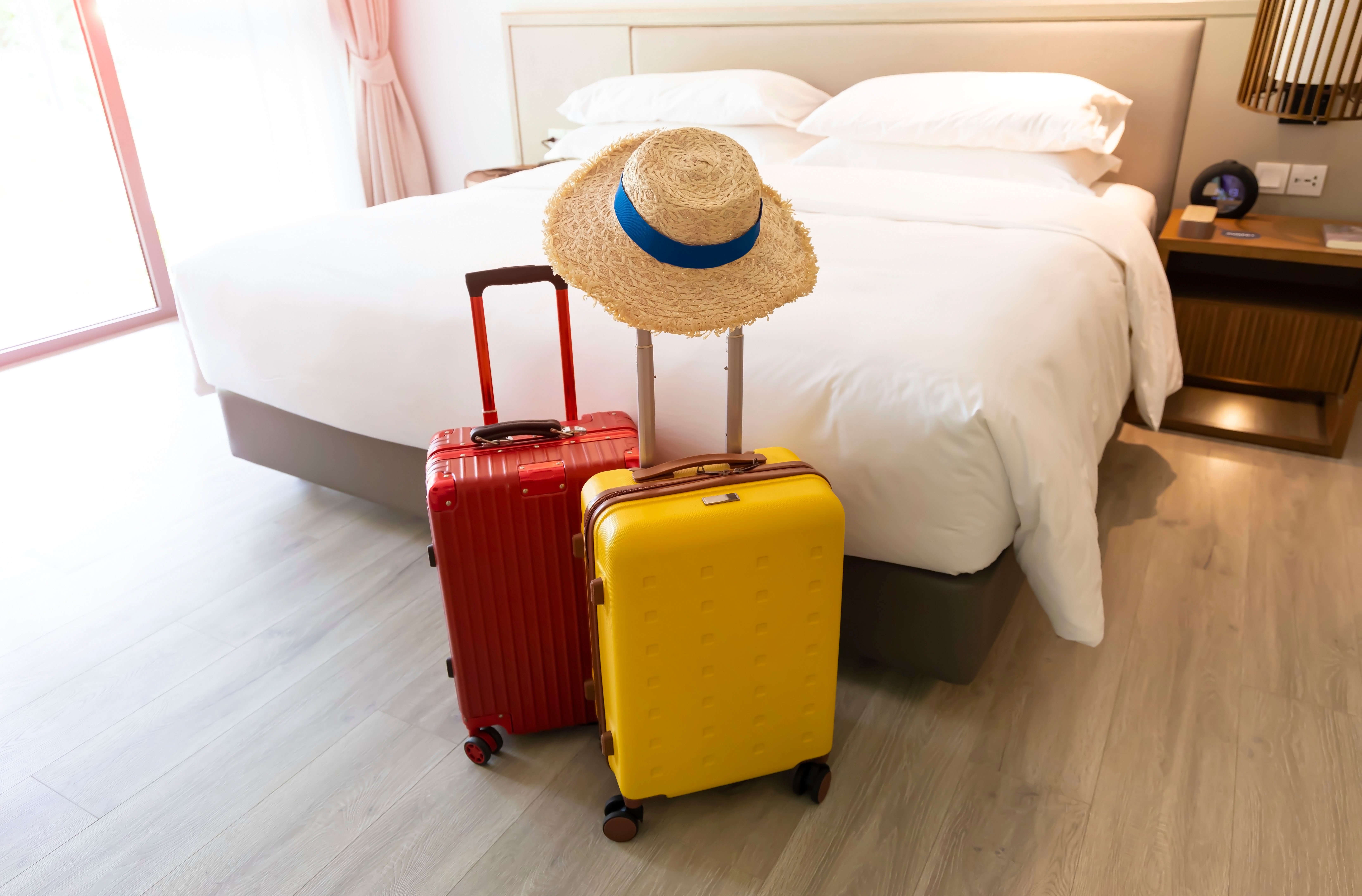 Two suitcases sitting at the end of bed. 